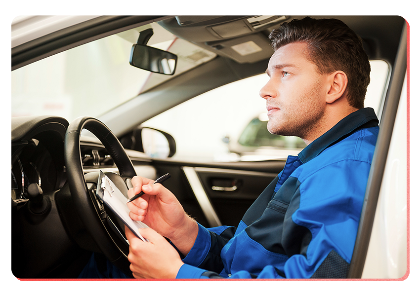 man in car filling out mileage log