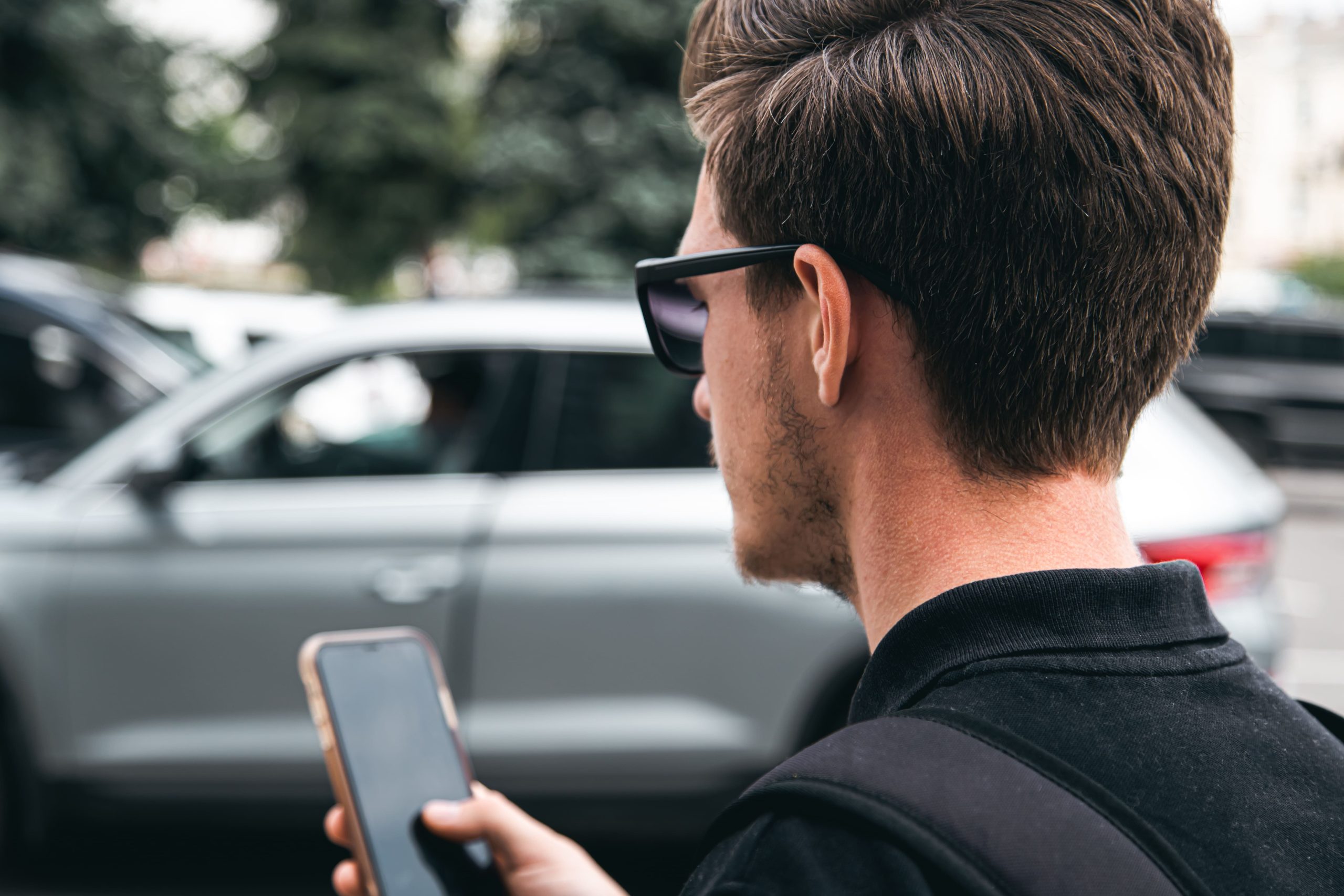 man with smartphone and car