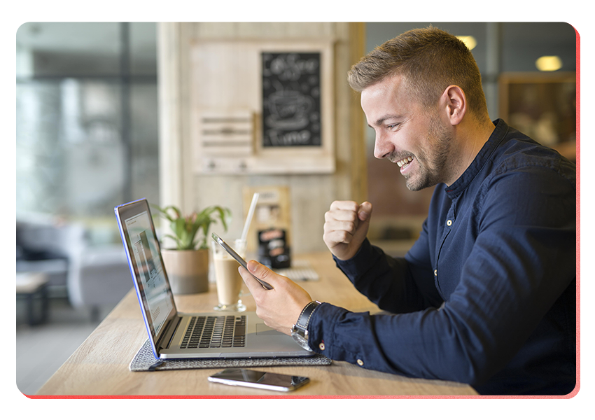 happy affiliate in front of laptop with phone