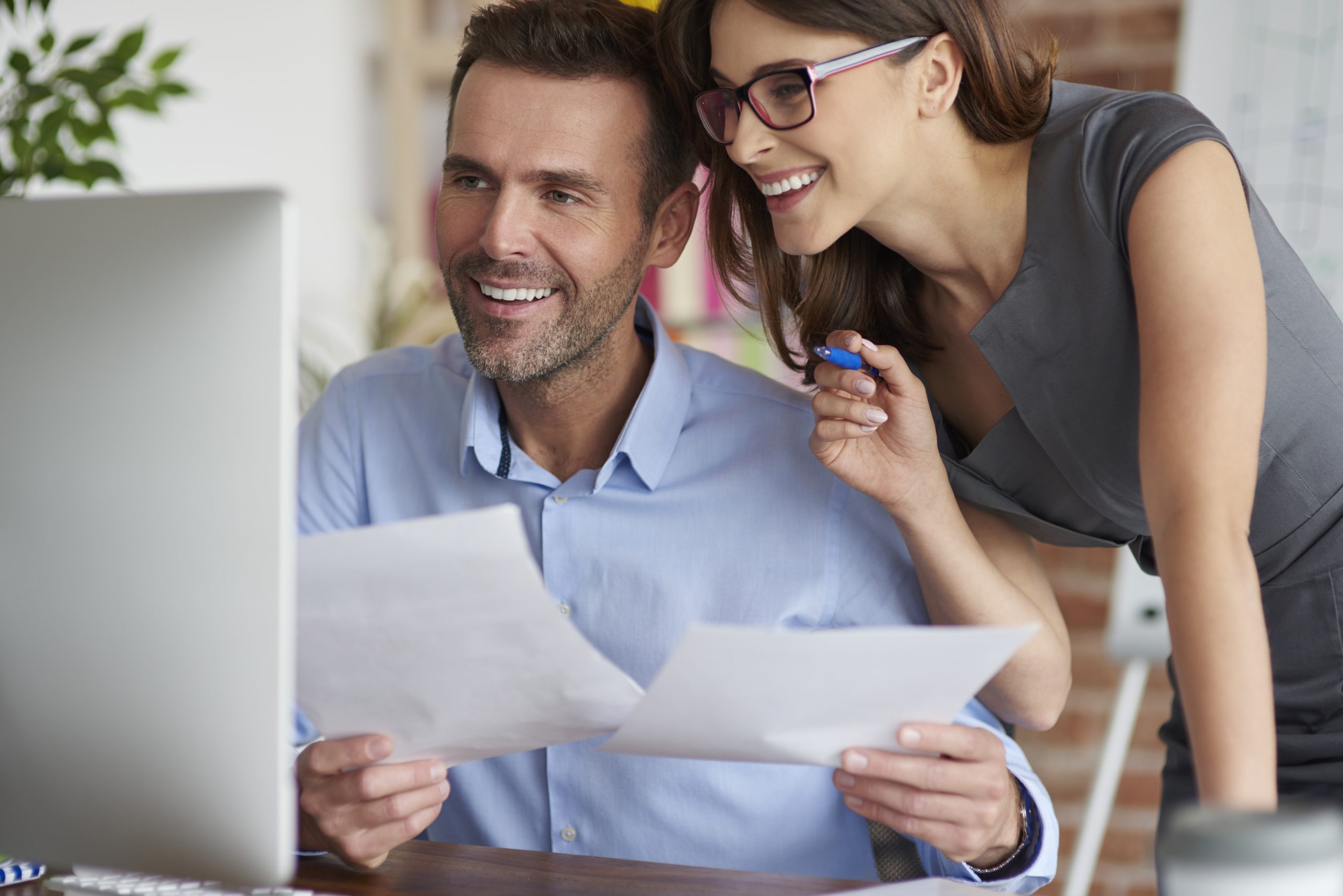 A couple carefully reviewing their Schedule C (Form 1040) form for accurate tax filing.