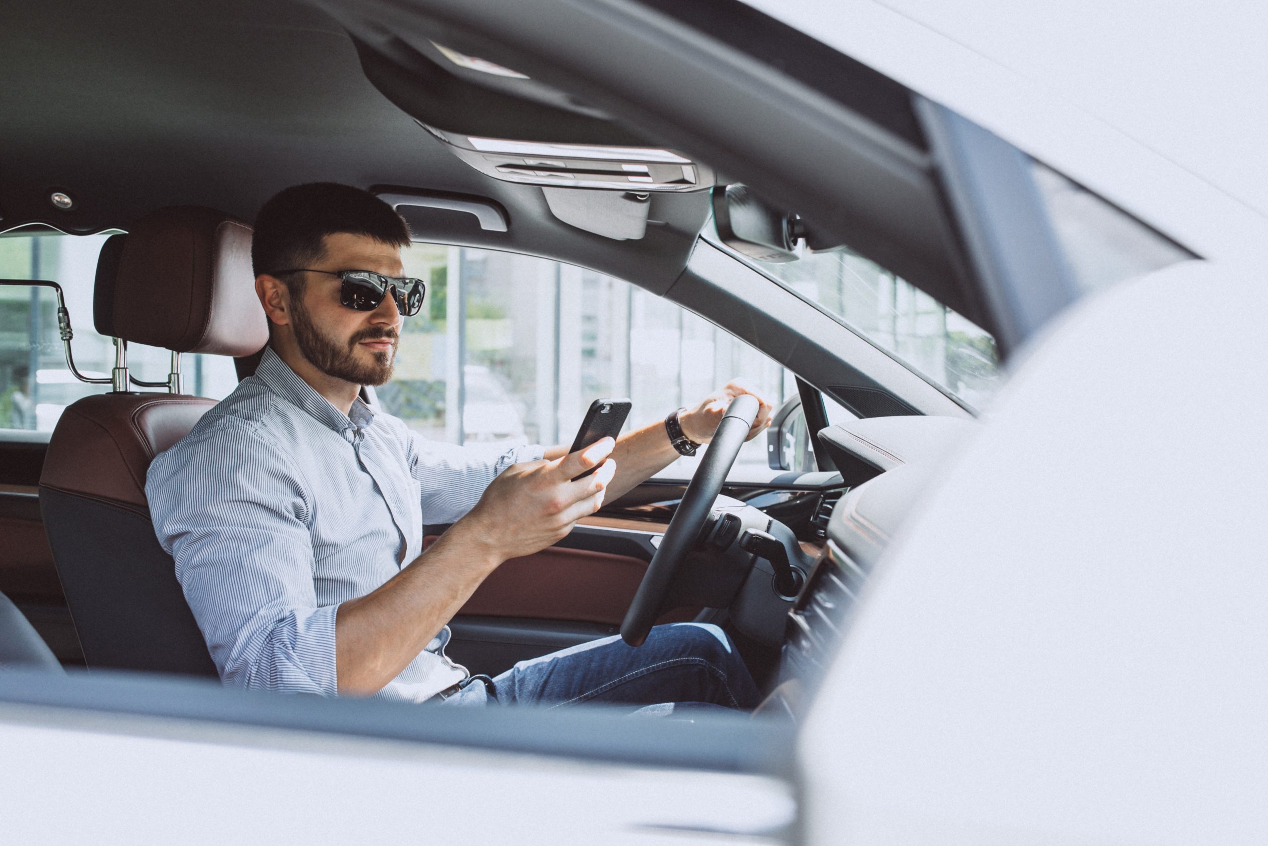 Entrepreneur engaging with the MileageWise app on his phone, effortlessly tracking his business mileage for optimal tax deductions.