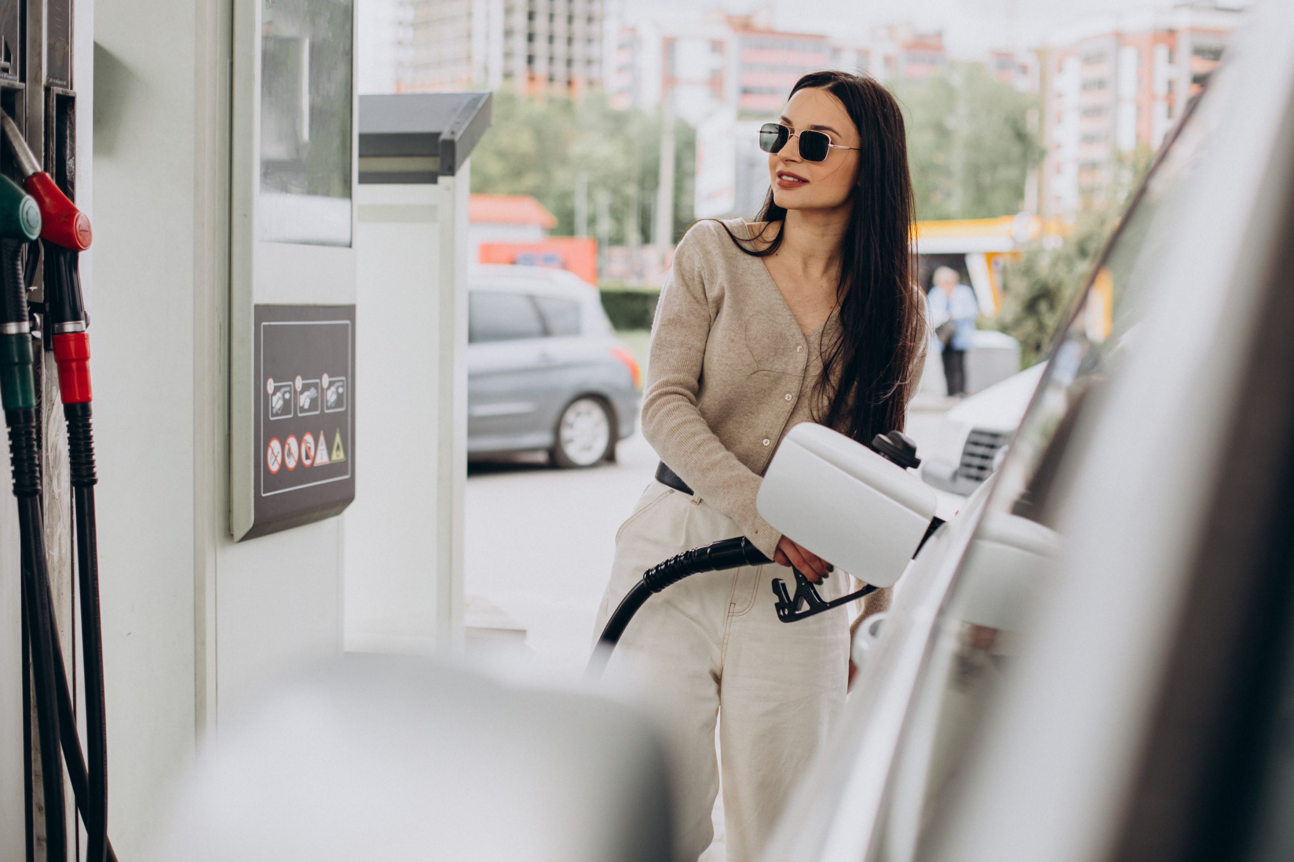 Confident female entrepreneur refuels her vehicle while seamlessly tracking her gas mileage with the user-friendly MileageWise app. She's maximizing efficiency, one fill-up at a time.