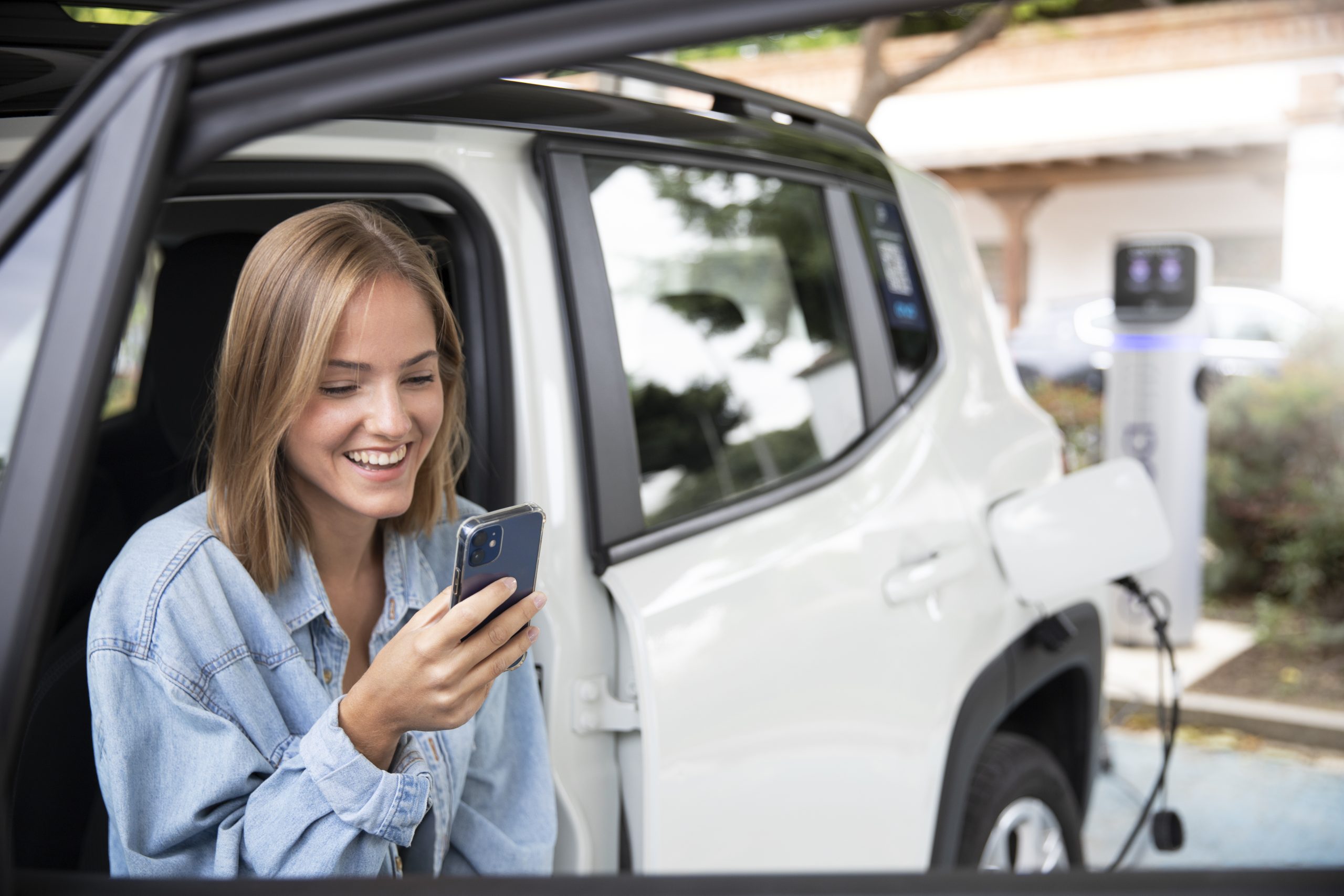 woman at gas station using phone