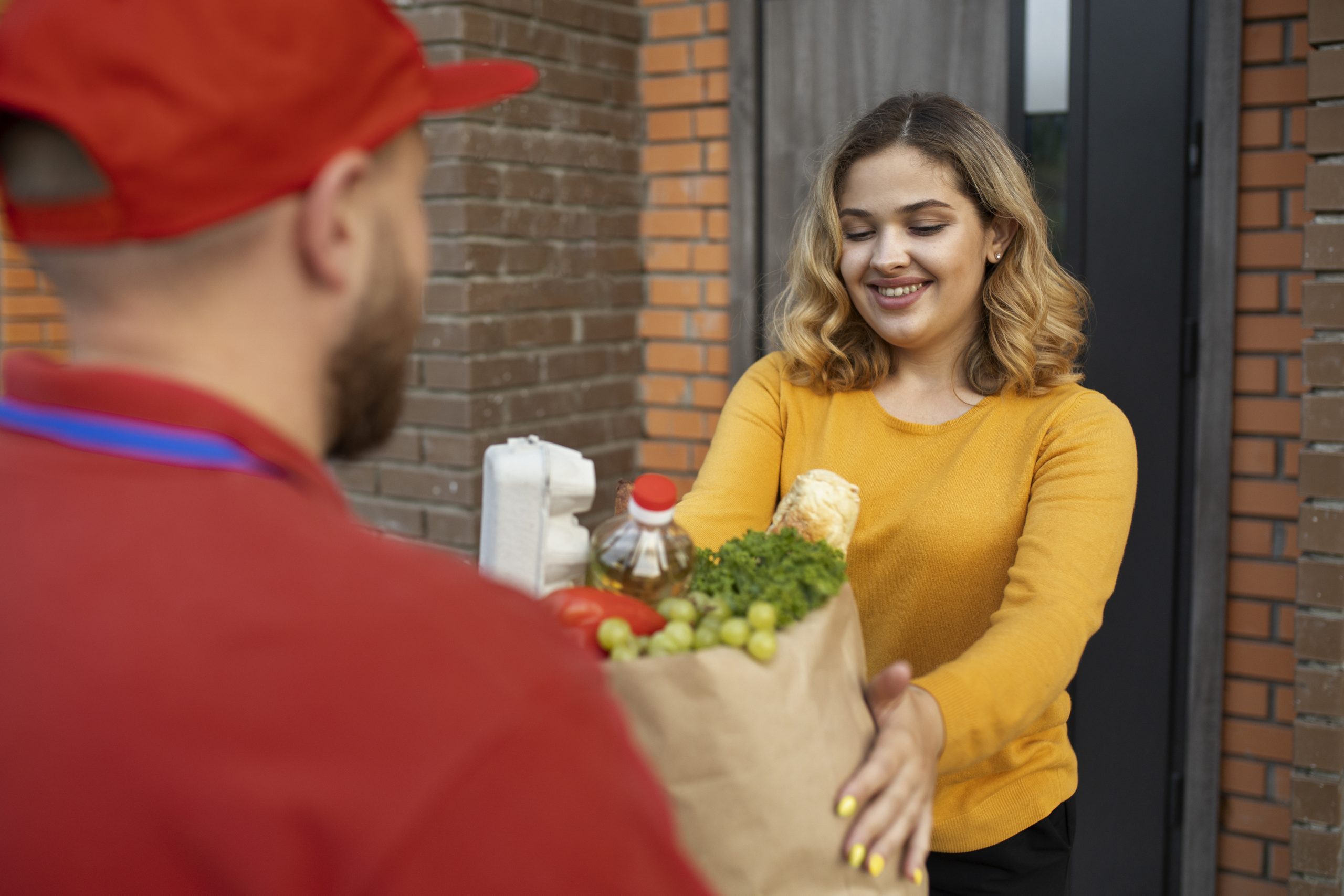 Courier delivering groceries while the DoorDash mileage tracker records his stop.