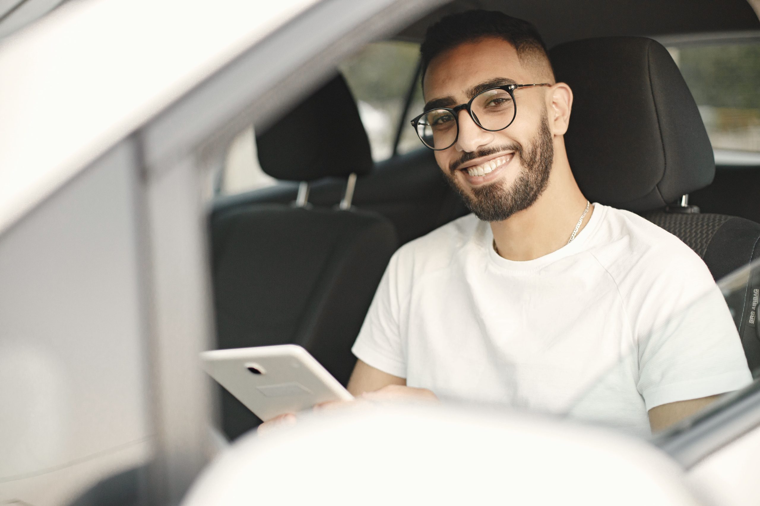 man reviews his digital mileage log for taxes in his car