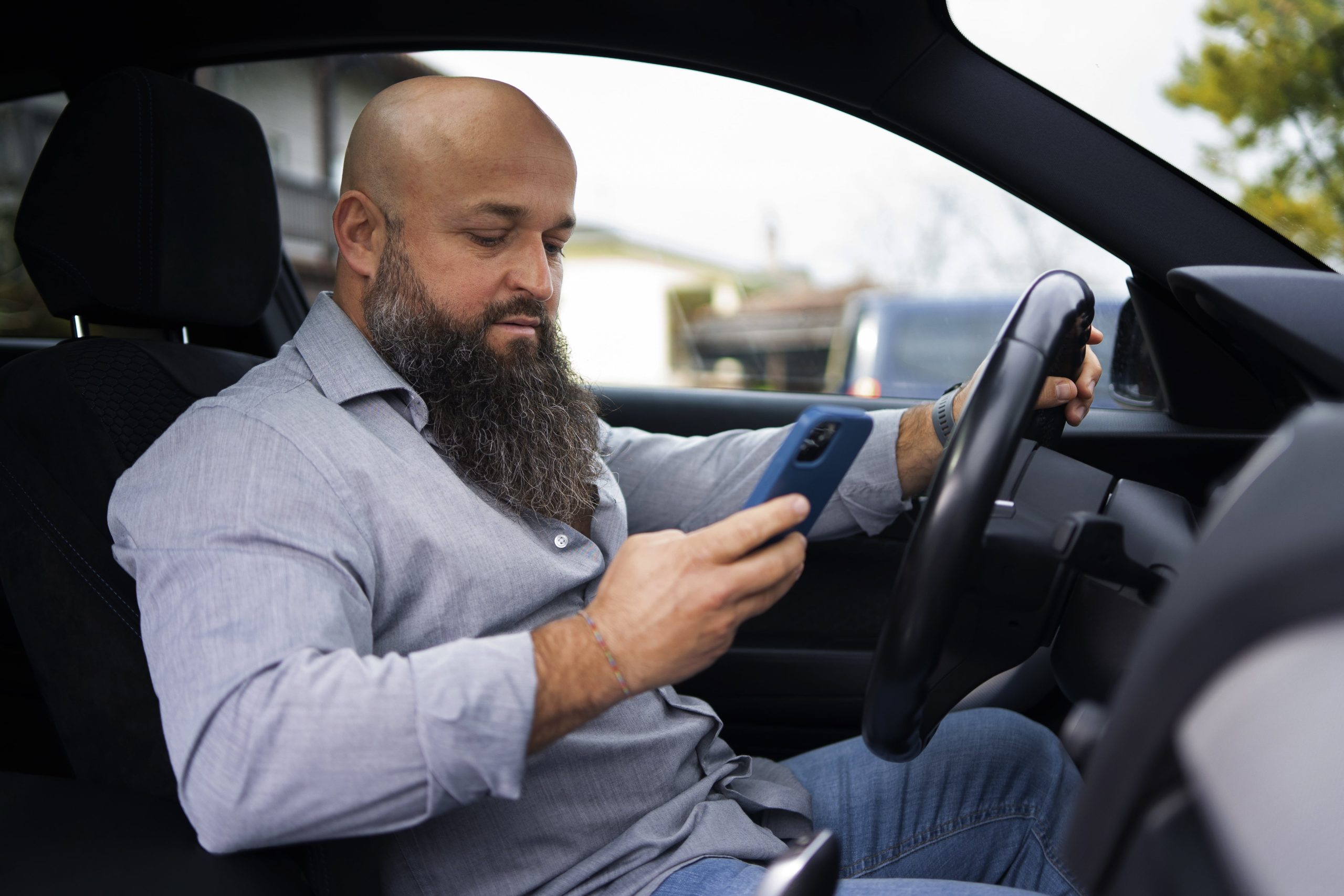 rideshare driver checks his tax-write off app between two rides